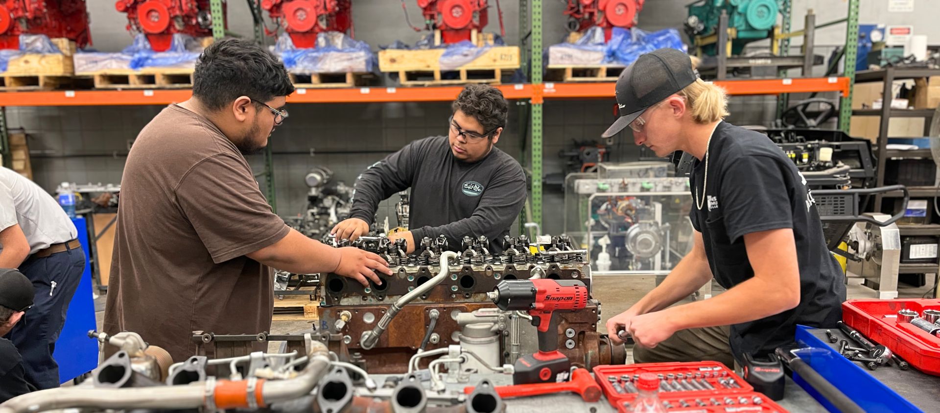 JCC Male Students working on a engine