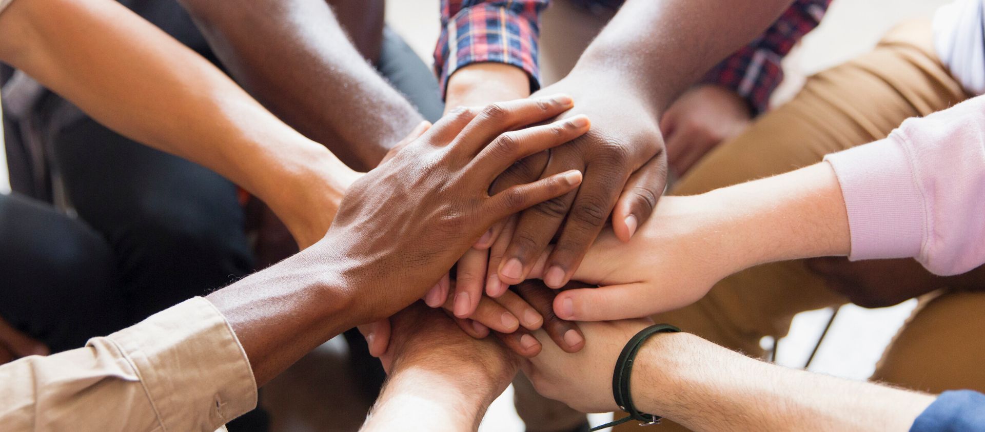 A group of hands of all colors piled on top of each other