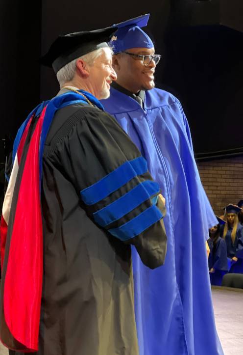 Photo of Dr. Lindquist and a JCC Graduate dressed in commencement regalia.