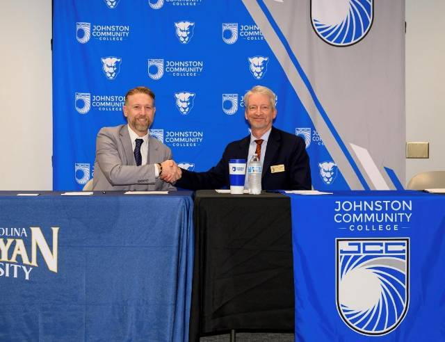 President of Johnston Community College  shakes hands with President of North Carolina Wesleyan University after partnership is achieved 