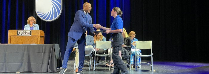 Dr. Marc David shaking hands with JCC Student