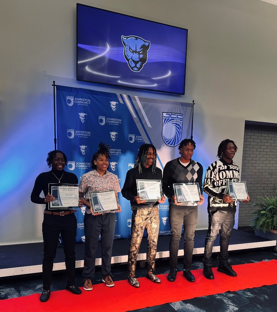 Five student athletes accepting awards