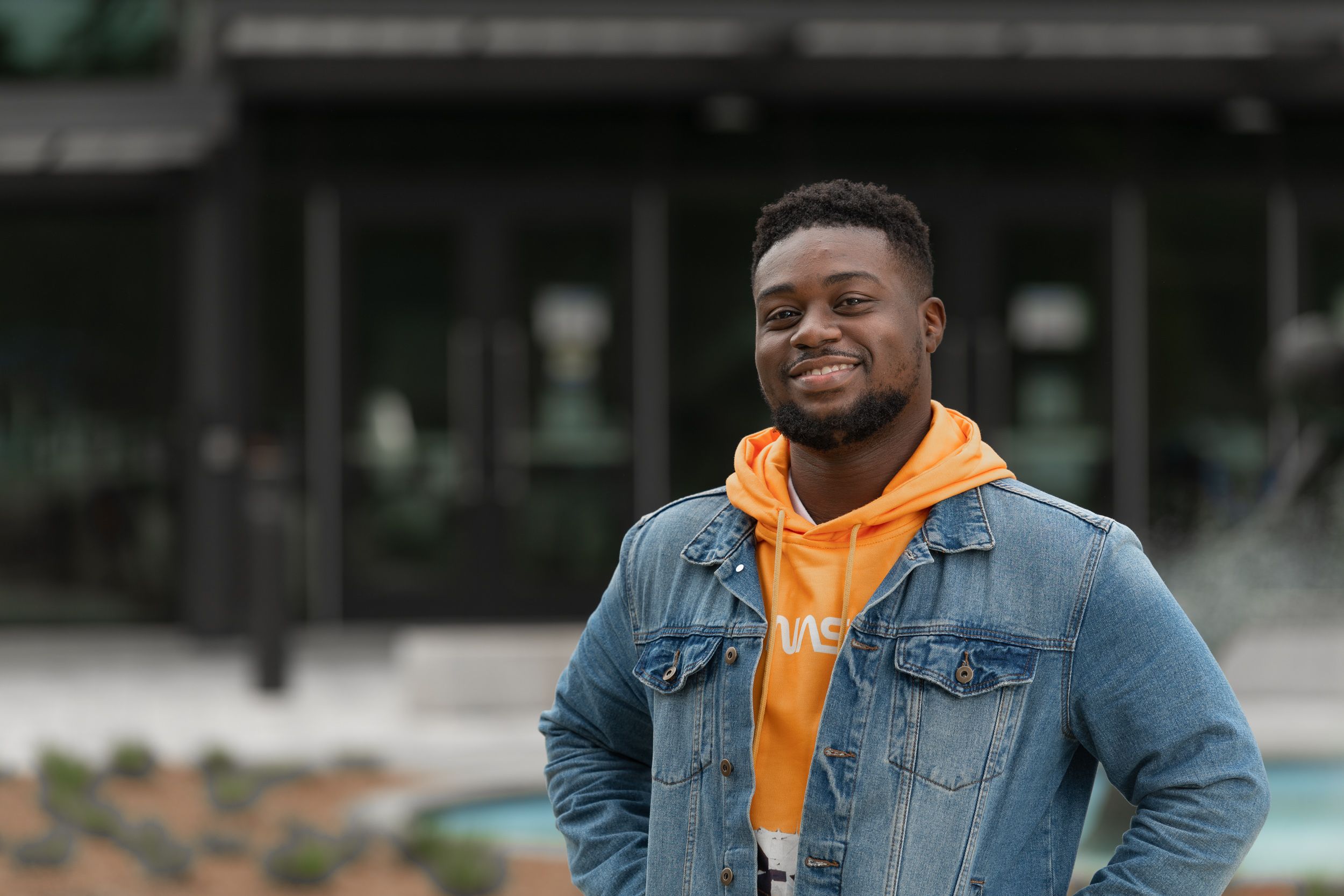 student in front of fountain on main campus