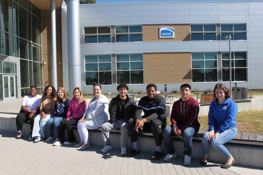 JCC Student Ambassadors sitting infront of the Wood Building