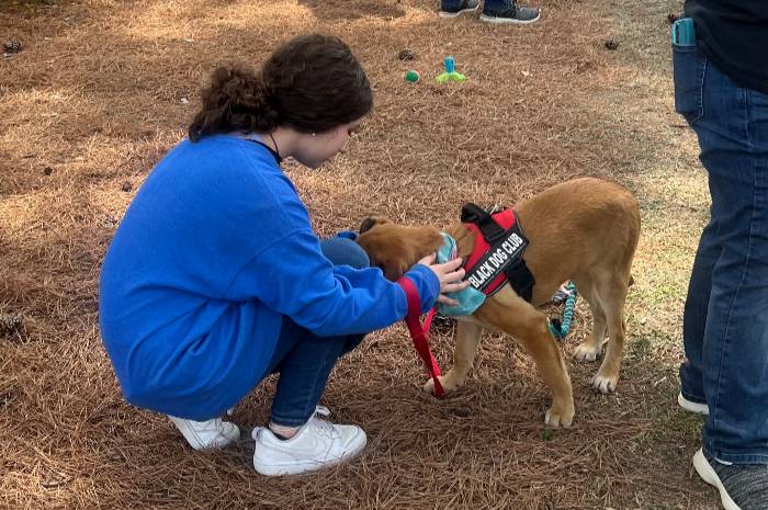 student petting support dog