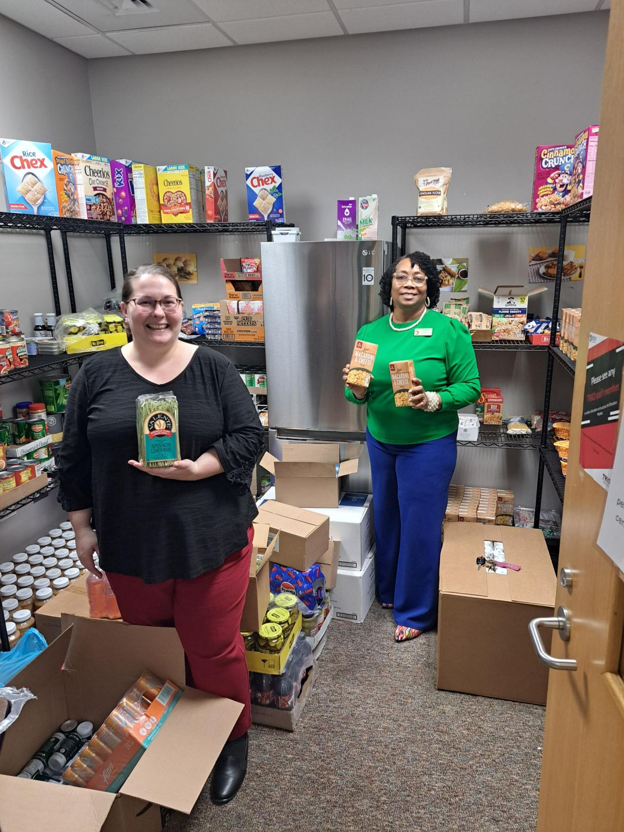 TRIO staff in Elevation Market holding food items from pantry